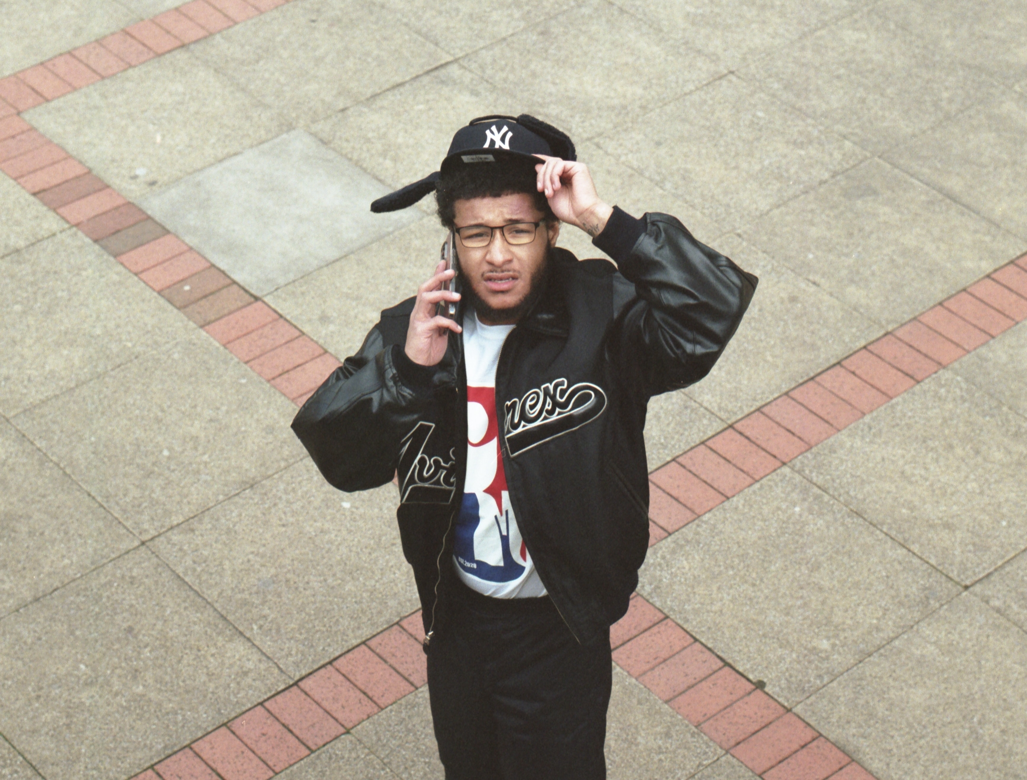 Squintz on the phone wearing a Yankees cap